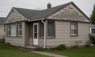 Before exterior repair view of a weathered bungalow facade in Loyalist