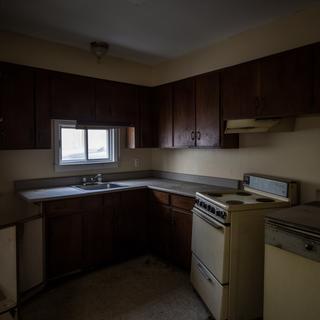 Before renovation view of a dark cabinet kitchen in Loyalist
