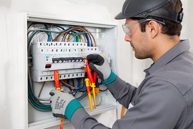 Raphaelle Greisman wiring a residential electrical panel with protective equipment